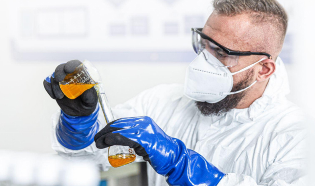 Scientist wearing blue nitrile gloves handling lab equipment.